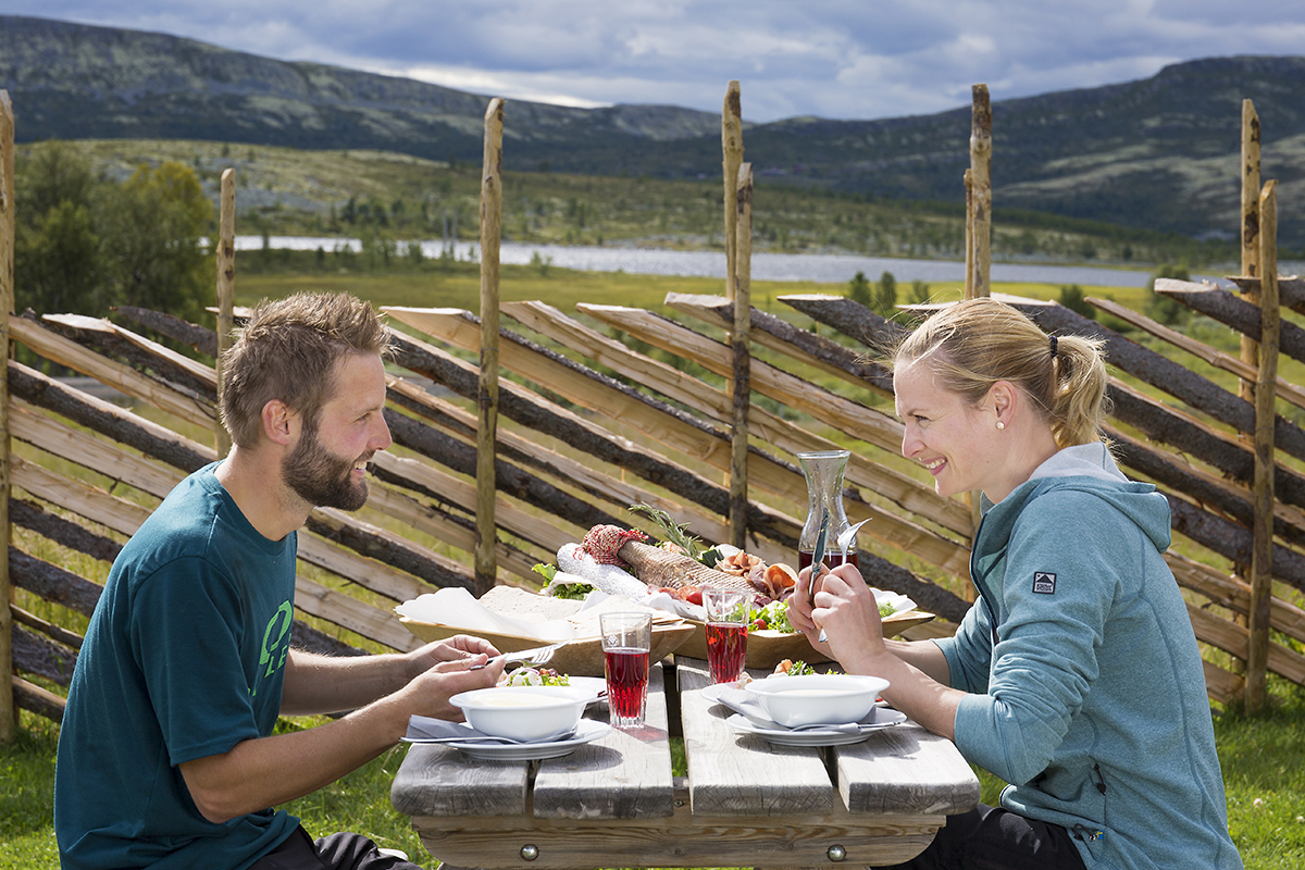 Par nyter måltid utendørs på Spidsbergseter Resort